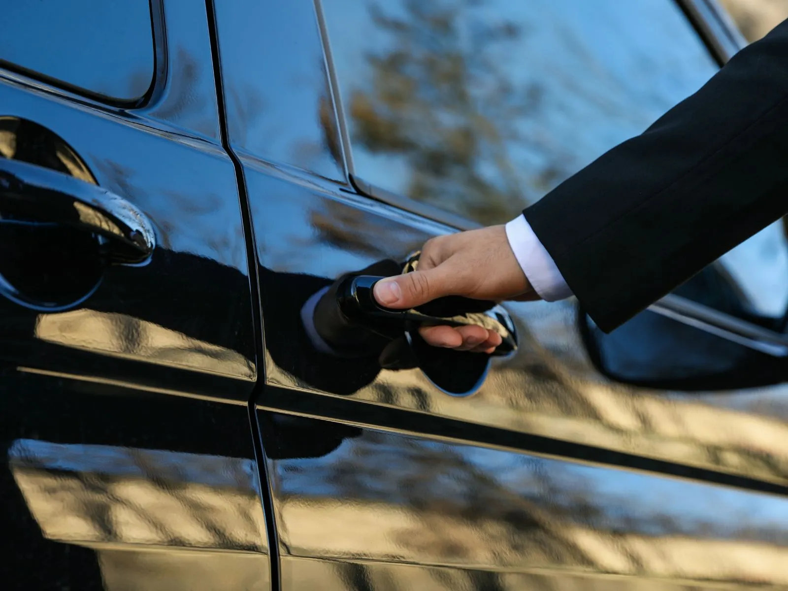 autista di noleggio con conducente che apre portiera auto